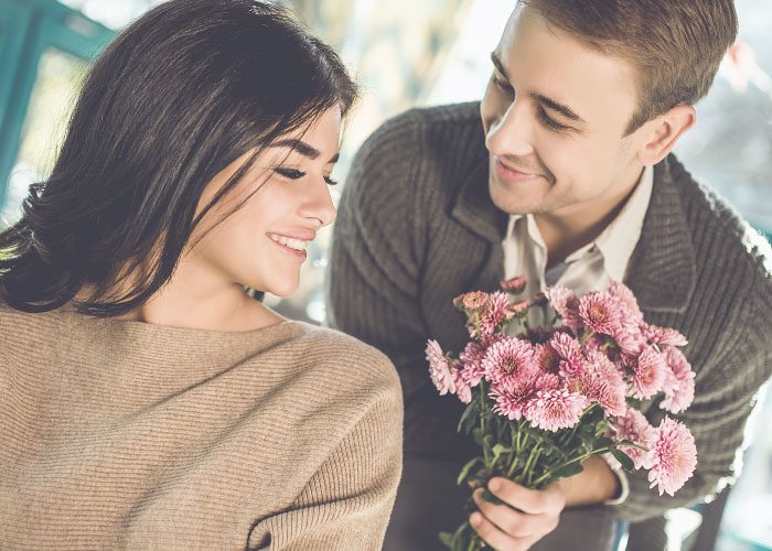 man gives flowers to the woman