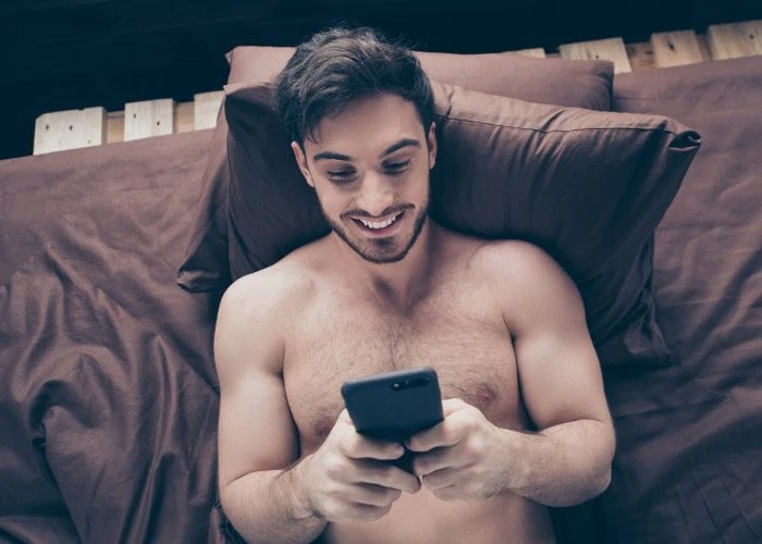 hapoy guy lying with phone