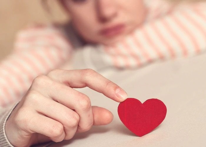 woman holds paper heart