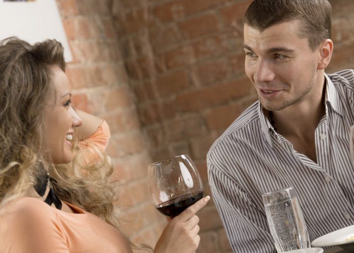 man talk to woman who drinks wine