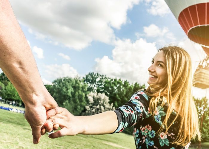 woman holds male hand